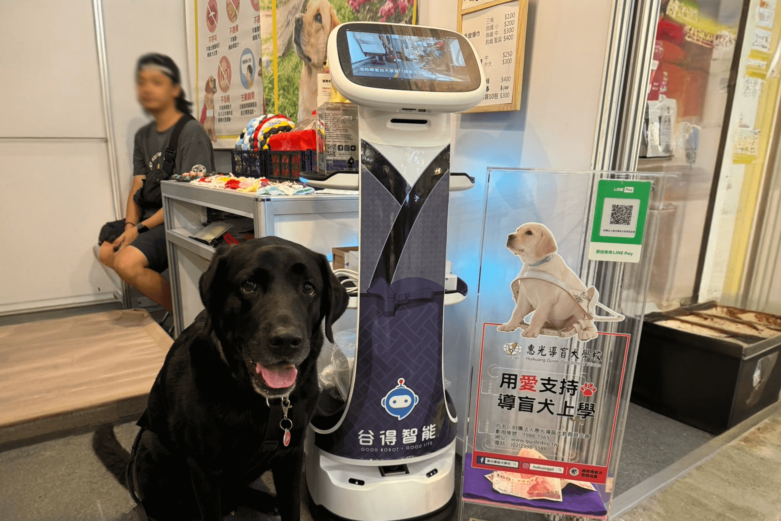 與導盲犬合照的遞送機器人